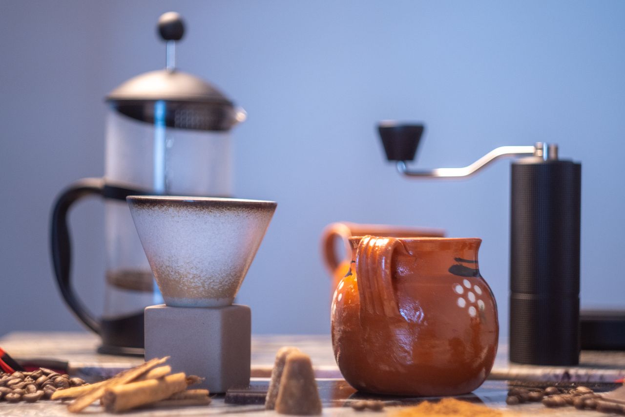 A vibrant cafe de olla setup with traditional Mexican utensils and ingredients, perfect for authentic coffee brewing.